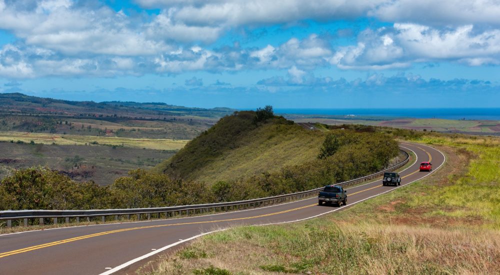 3 rental cars driving away from the camera in Hawaii